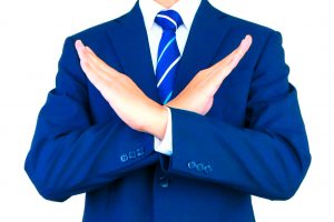 腕を交差させて「禁止」や「拒否」を示すビジネスマン